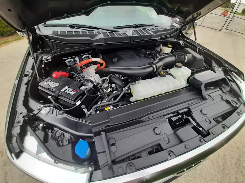 Shrouding, plumbing, and wiring hide the twin-turbo V-6 that’s backed by an electric motor. Only the PowerBoost name and orange-wrapped wiring (carrying 400 volts in this system) hint that this is a fuel-saving and performance-enhancing hybrid powertrain.