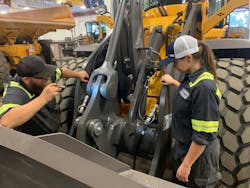 J-Tech Institute graduates and Alta Equipment Company technicians TJ Wright and Tiffany Roberts examine a wheel loader at Alta&rsquo;s Jacksonville location.