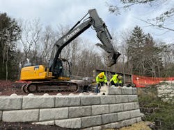 Rutledge workers place stone on a retaining wall and small bridge project. Rutledge workers place stone on a retaining wall and small bridge project.