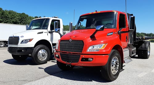 Viper red Class 7 eMV poses with a Cummins diesel-powered MV, International&rsquo;s popular Medium Vocational model, at the Navistar Proving Grounds in Indiana. Cabs, frames, and suspensions are shared between the two otherwise dissimilar vehicles, though eMV&rsquo;s gauge cluster is digital (inset). The drive system is taken from Navistar&rsquo;s proven IC electric school buses. The eMV&rsquo;s range is 135 miles, depending on operations, and the goal for future models is 200 miles. A Class 6 version for non-CDL drivers is also offered.