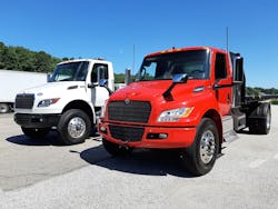 Viper red Class 7 eMV poses with a Cummins diesel-powered MV, International&rsquo;s popular Medium Vocational model, at the Navistar Proving Grounds in Indiana. Cabs, frames, and suspensions are shared between the two otherwise dissimilar vehicles, though eMV&rsquo;s gauge cluster is digital (inset). The drive system is taken from Navistar&rsquo;s proven IC electric school buses. The eMV&rsquo;s range is 135 miles, depending on operations, and the goal for future models is 200 miles. A Class 6 version for non-CDL drivers is also offered.