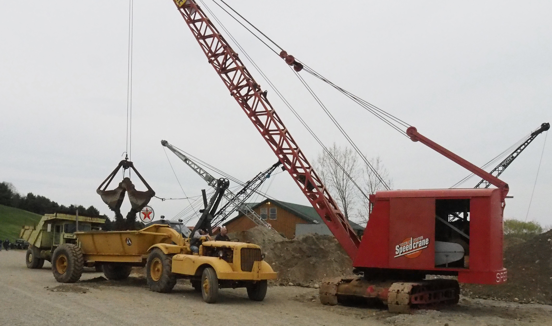 A fully restored Manitowoc 125 Speedcrane hard at work during the 2022 Open House of Lakeside Sand & Gravel. It&rsquo;s loading a bottom dump wagon drawn by a Cat DW10. The Open House is held the last Saturday of each April at the Lakeside plant in Mantua, off the Ohio Turnpike between Exits 187 and 193 east of Cleveland. It features machines from Lakeside&rsquo;s extensive collection, admission is free, and all proceeds from lunches served go to the Hattie Larlham Foundation, a local charity serving the developmentally disabled.