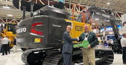 Martin Mattsson, key accounts director — waste and recycling at Volvo CE (left), hands over the EC230 Electric keys to Harold Romberg, director of heavy equipment for WM, at Waste Expo. Martin Mattsson, key accounts director — waste and recycling at Volvo CE (left), hands over the EC230 Electric keys to Harold Romberg, director of heavy equipment for WM, at Waste Expo.