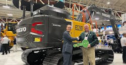 Martin Mattsson, key accounts director &mdash; waste and recycling at Volvo CE (left), hands over the EC230 Electric keys to Harold Romberg, director of heavy equipment for WM, at Waste Expo.