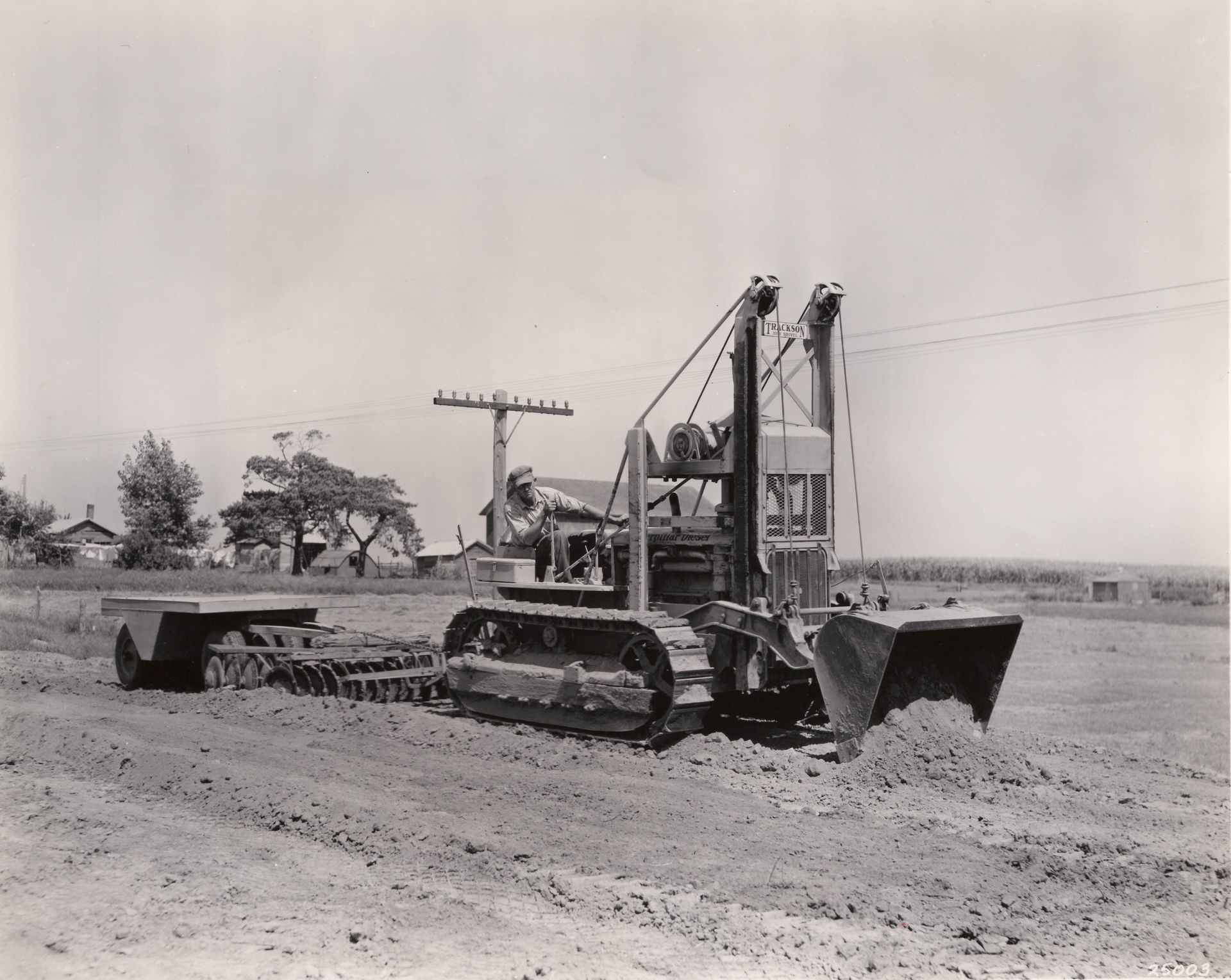 On a road job near Galva, Illinois, in September, 1938, a Cat D4 with a High Loader is spreading fill, plus towing a disc and a pneumatic roller. It also ditched, placed pipe, and cleared brush. The machine handled excavation as well, including overburden, gravel, and earth and rock cuts.