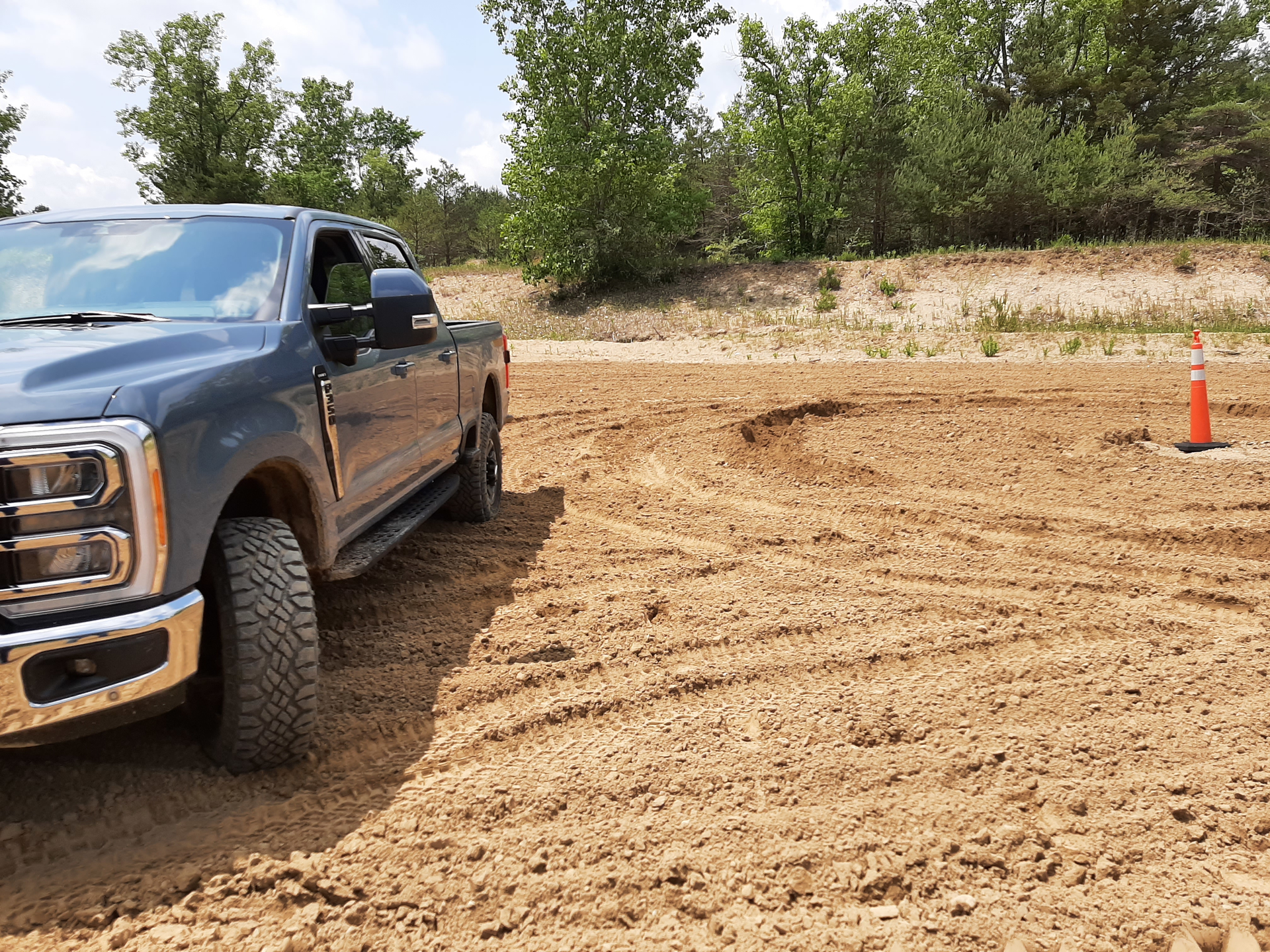 Trail Turn Assist feature applies inside rear-wheel brake to drag the truck through turns and drastically reduce a turning circle, as shown by ruts in the sand near the cone. Without Trail Turn Assist, Super Duty 4x4 took much more room to turn.