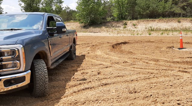 Trail Turn Assist feature applies inside rear-wheel brake to drag the truck through turns and drastically reduce a turning circle, as shown by ruts in the sand near the cone. Without Trail Turn Assist, Super Duty 4x4 took much more room to turn.