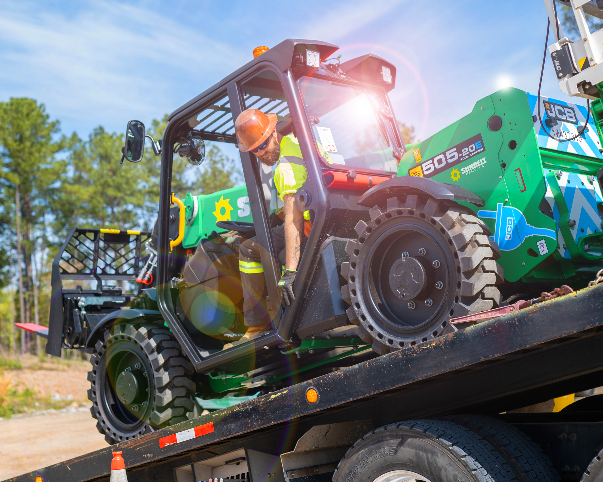 An JCB Loadall electric telehandler is unloaded on a job site. Telehandlers, and other small equipment with traditionally high idle times, were natural starters for rental companies looking to offer electric equipment.
