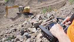 An operator uses a Cat Command console to operate an excavator. This portable line-of-sight technology can be carried in the cab to switch from manual to remote-control operation any time the operator decides to exit the cab and step away from a hazardous situation. An operator uses a Cat Command console to operate an excavator. This portable line-of-sight technology can be carried in the cab to switch from manual to remote-control operation any time the operator decides to exit the cab and step away from a hazardous situation.