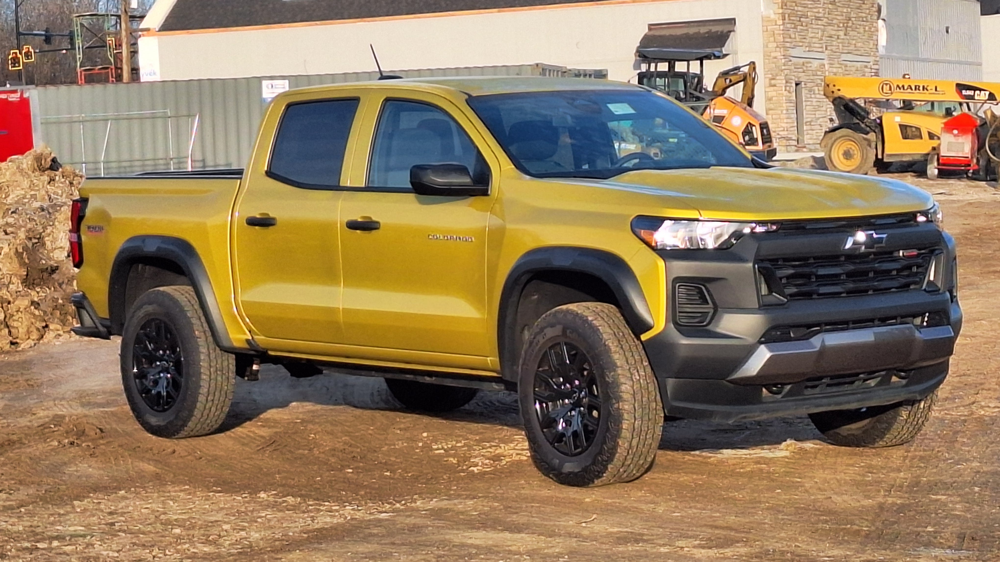 Nitro Yellow paint and edgy styling seem appropriate for a work site. The Colorado is about 10 percent smaller than a GMC Sierra (inset) or its Chevy Silverado twin, so it is easier to maneuver in everyday driving. Depending on equipment, a mid-size truck also costs $10,000 to $20,000 less.
