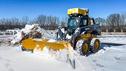 A Deere 332G skid steer with a snow plow for remote operation.