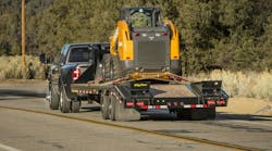 Ram towing a skid steer. Ram towing a skid steer.