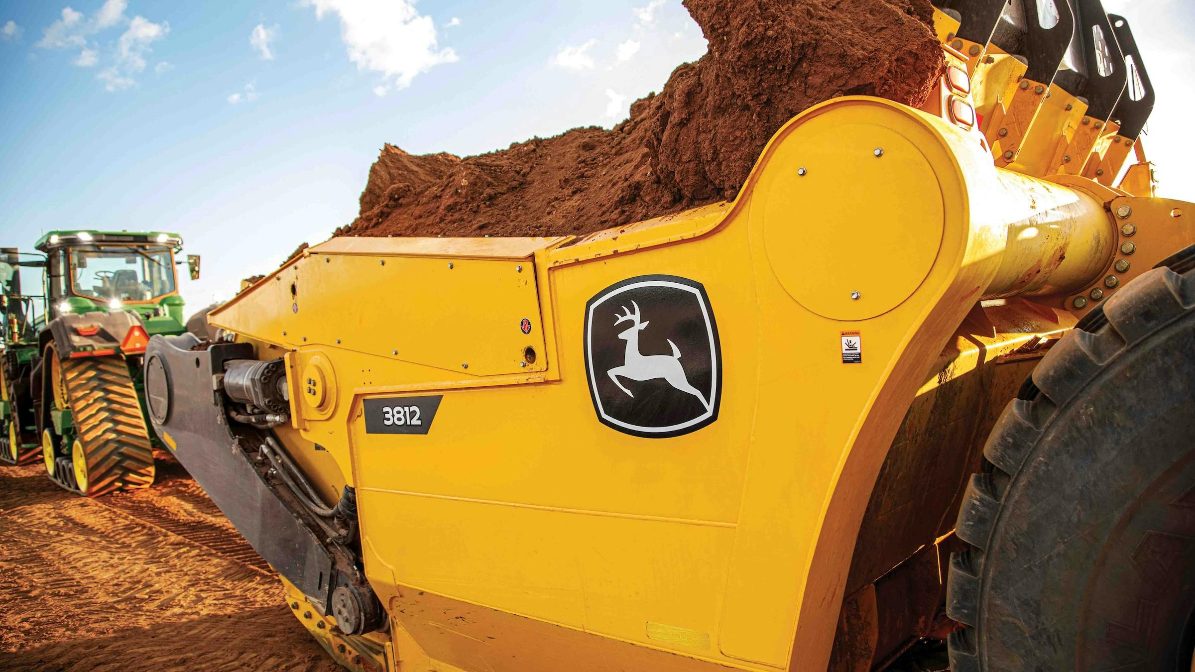 Deere 3812 scraper has a 38-cubic-yard capacity and pairs with the Deere 9RX 710 and 770 tractors.