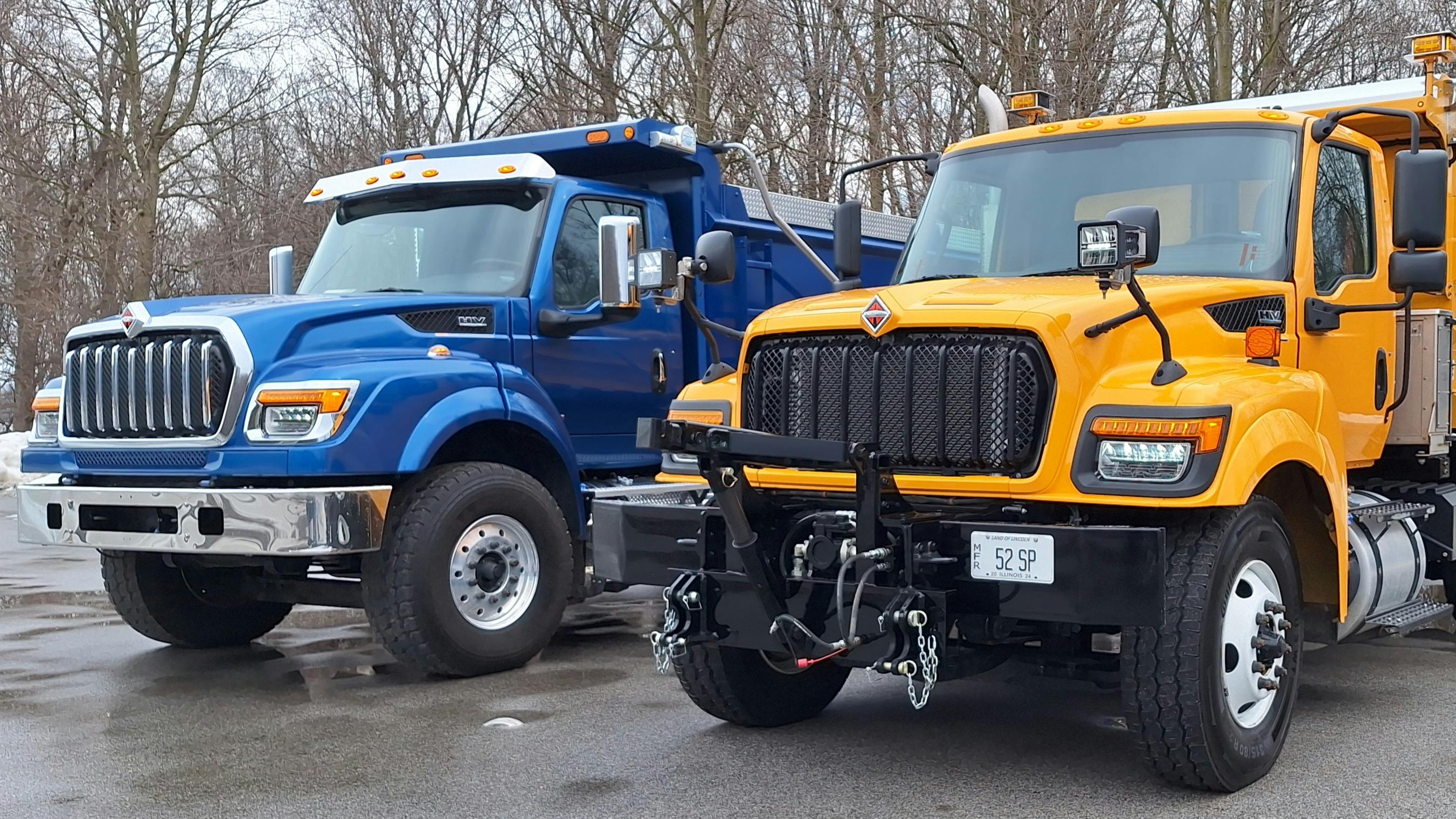 Blue HV615 has a setback steer axle, a longer hood housing an International S13 diesel and a bumper-to-back-of-cab dimension of 115 inches. Shorter yellow HV509, with a 109-inch BBC, has a Cummins L9 and a set-forward steer axle to support heavy snowplow equipment. Its flat-black grille suggests frugality but the truck has highly capable components and a stoutly engineered chassis.