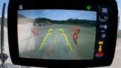 The system highlights people in red bounding boxes on the in-cab monitor. The system highlights people in red bounding boxes on the in-cab monitor.