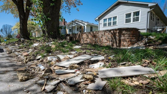 Debris and building materials remain scattered along the sidewalk on Franklin Avenue on Tuesday, April 15, 2025, in Lexington, Missouri, after a gas explosion shattered windows and damaged nearby structures.