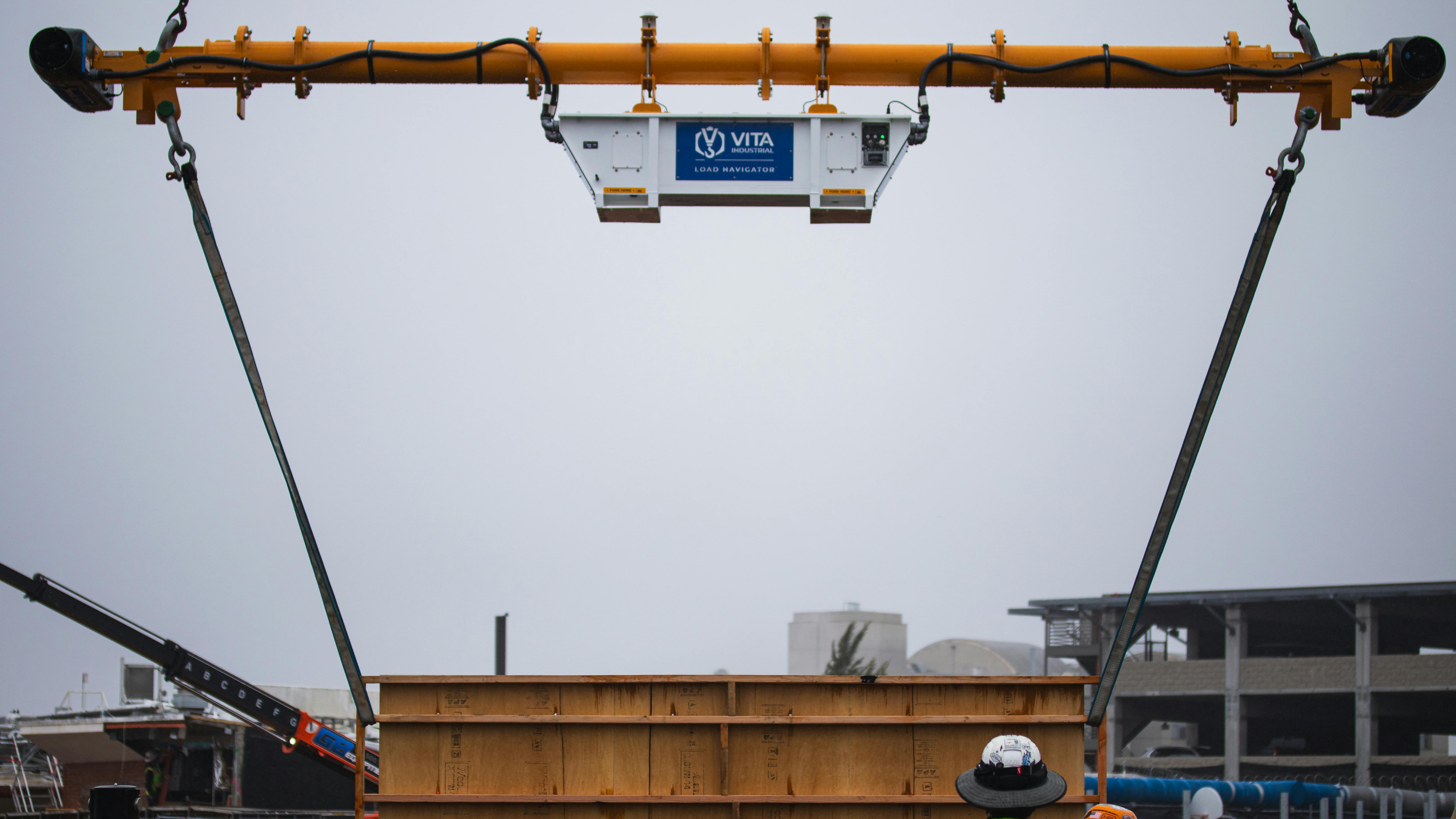 The device connects below the crane hook.