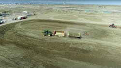 Trailers dumped dirt in windrows, and a tractor towing a disc (far right) compacted the material. Trailers dumped dirt in windrows, and a tractor towing a disc (far right) compacted the material.