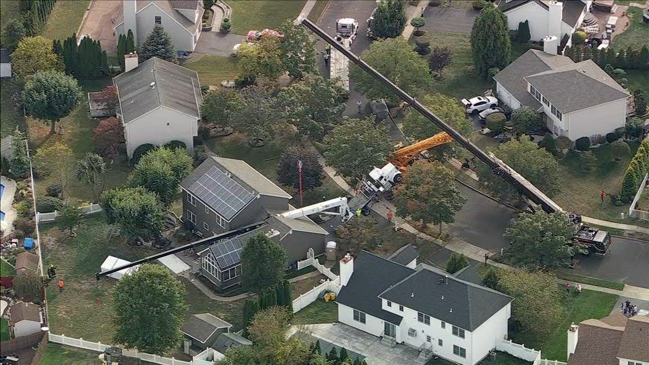 Crane collapses onto NJ home while moving hot tub