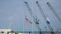 A green flag with the company logo for Archer Western Construction hangs from a crane near another flag for the Florida Department of Transportation, next to the new lanes of the new Howard Frankland Bridge on March 24, 2025. A Tampa Bay Times investigation about Archer Western has prompted Florida politicians to call for state officials to hold the company accountable. A green flag with the company logo for Archer Western Construction hangs from a crane near another flag for the Florida Department of Transportation, next to the new lanes of the new Howard Frankland Bridge on March 24, 2025. A Tampa Bay Times investigation about Archer Western has prompted Florida politicians to call for state officials to hold the company accountable.