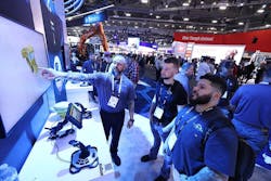 CONEXPO booth inside three men looking at a screen CONEXPO booth inside three men looking at a screen