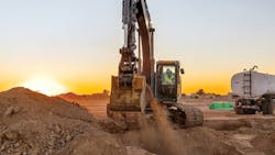 John Deere 260 crawler excavator digging the dirt with a sunset in the background John Deere 260 crawler excavator digging the dirt with a sunset in the background