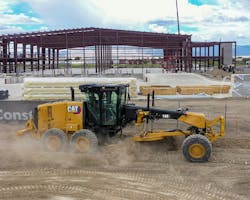 Caterpillar 140 motor grader grading dirt on a construction site Caterpillar 140 motor grader grading dirt on a construction site
