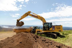 Komatsu PC220LC-12 excavator dumping dirt into an ADT Komatsu PC220LC-12 excavator dumping dirt into an ADT