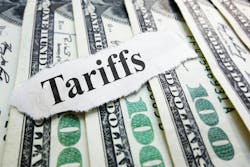 Money laying on a surface with a piece of paper that says Tariffs. Money laying on a surface with a piece of paper that says Tariffs.