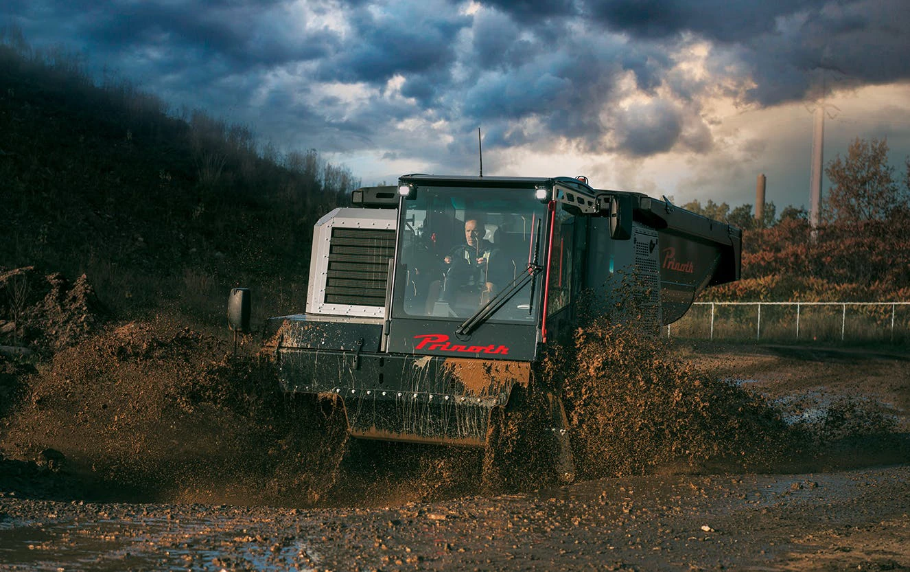 Prinoth Panther T23r Crawler Carrier rolling through the mud.