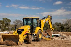 Caterpillar 416 backhoe loader digging dirt for a utility Caterpillar 416 backhoe loader digging dirt for a utility