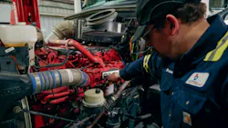 Fleetio mechanic checking a red engine Fleetio mechanic checking a red engine