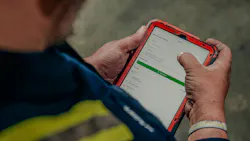 Fleetio software on a tablet with a mechanic checking it Fleetio software on a tablet with a mechanic checking it