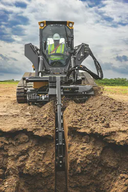 John Deere trencher attachment cutting through the dirt. John Deere trencher attachment cutting through the dirt.