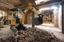 JCB 19C-1E mini excavator digging indoors. JCB 19C-1E mini excavator digging indoors.