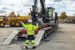 Volvo Construction Equipment excavator delivery, guy helping off load. Volvo Construction Equipment excavator delivery, guy helping off load.