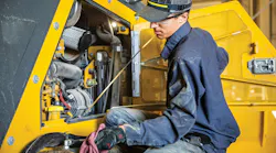 Mechanic checking the oil on a John Deere machine.