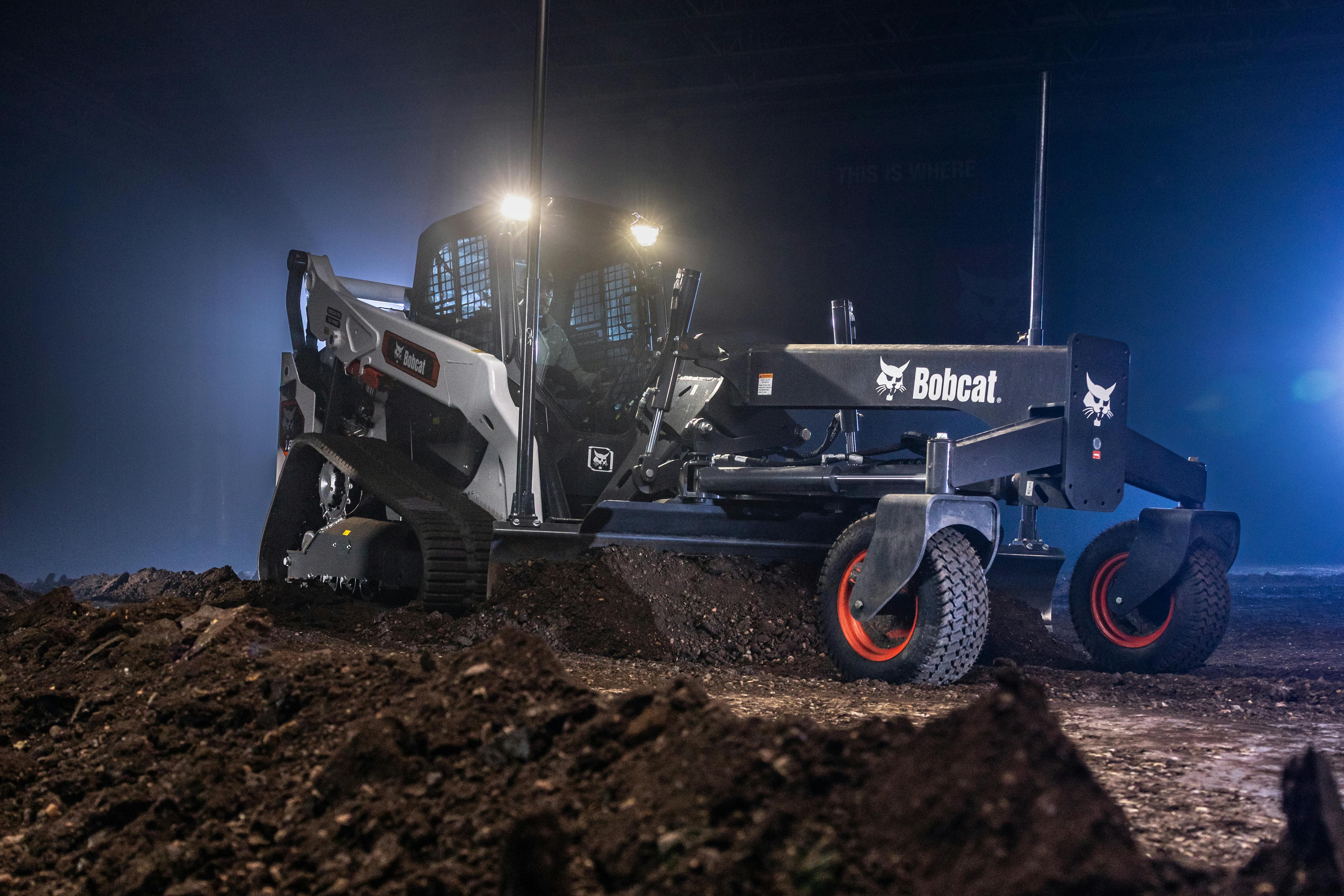 Bobcat T86-2 compact track loader with a grader blade and lights ablazin'.