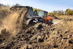 Develon 1027 wheel loader lifting dirt and rolling large. Develon 1027 wheel loader lifting dirt and rolling large.