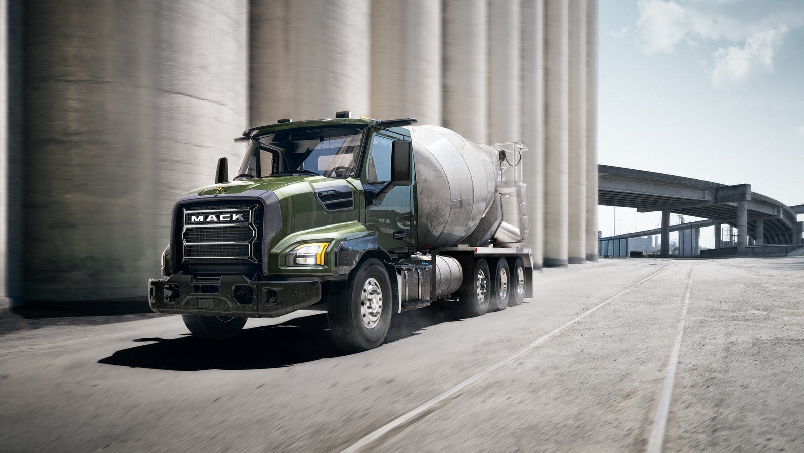 Mack Granite concrete mixer truck, sitting near a highway.