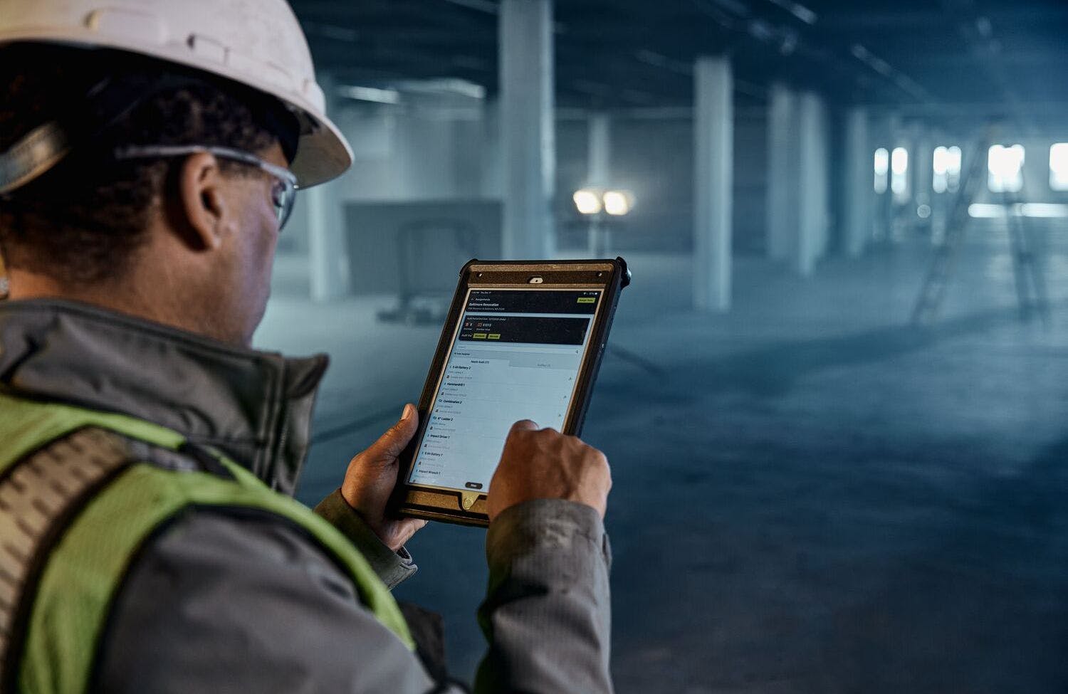 Dewalt Ecomm Tool connect image. Man on tablet inside building.