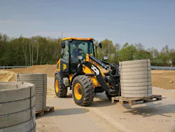 JCB 409 wheel loader holding a pallet of concrete. JCB 409 wheel loader holding a pallet of concrete.