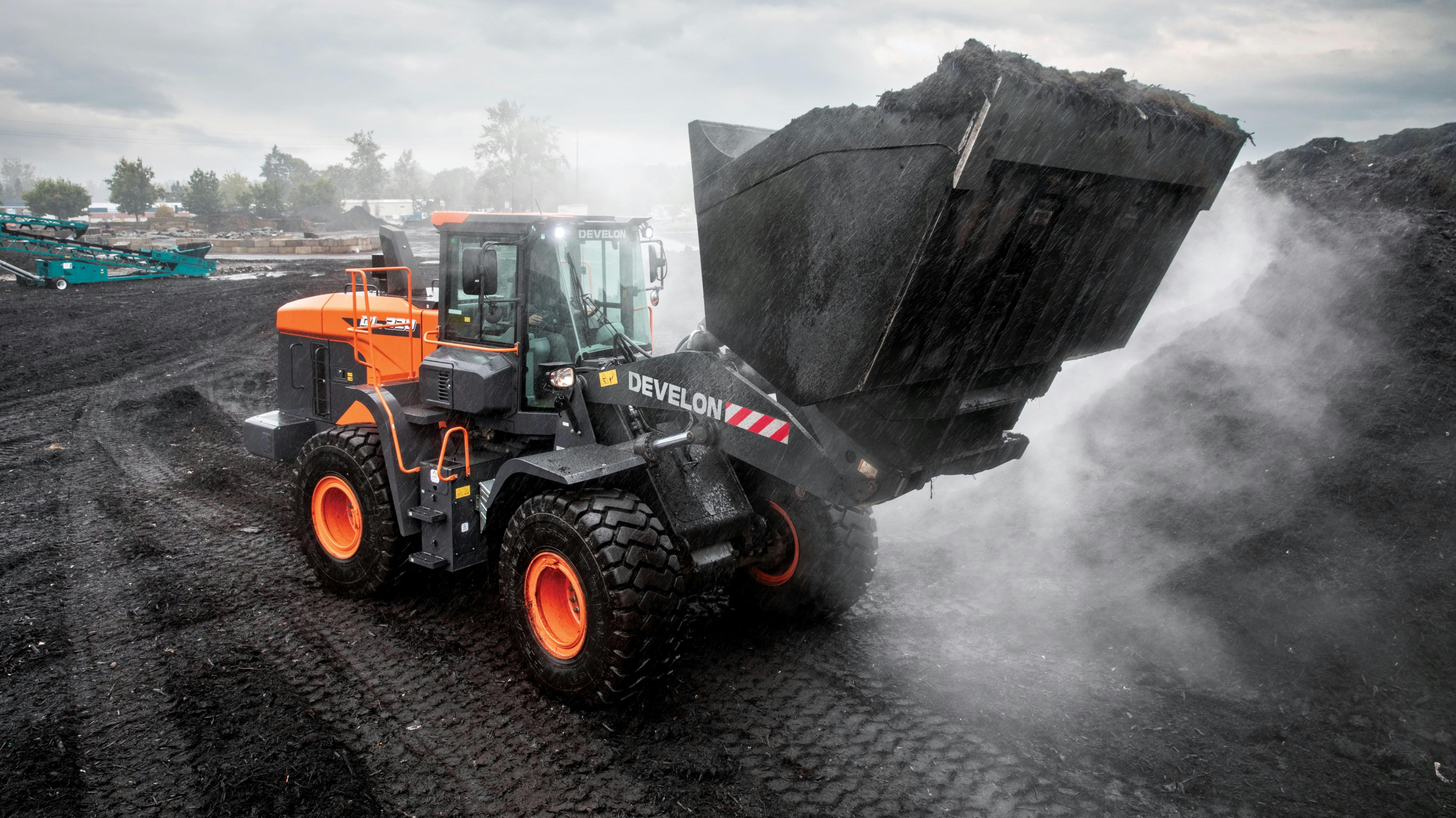 Develon DL320-7 wheel loader moving mulch.