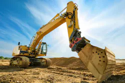 Big excavator in front of the blue sky. Big excavator on new construction site, in the background the blue sky and sun Big excavator in front of the blue sky. Big excavator on new construction site, in the background the blue sky and sun
