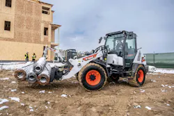 Bobcat compact wheel loader carrying rebar on pallet forks. Bobcat compact wheel loader carrying rebar on pallet forks.