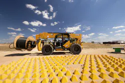 Caterpillar TH1255 telehandler holding a cable reel. Caterpillar TH1255 telehandler holding a cable reel.