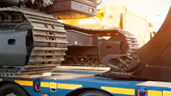 Excavator sitting on a trailer with sunlight streaming in. Excavator sitting on a trailer with sunlight streaming in.