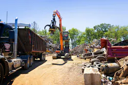 Develon DX225MH-5 material handler near a haul truck. Develon DX225MH-5 material handler near a haul truck.
