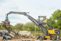 Volvo Construction Equipment EW240 Material Handler picking up scrap. Volvo Construction Equipment EW240 Material Handler picking up scrap.