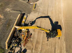 Caterpillar’s MH3032 material handler reaching into a scrap yard. Caterpillar’s MH3032 material handler reaching into a scrap yard.